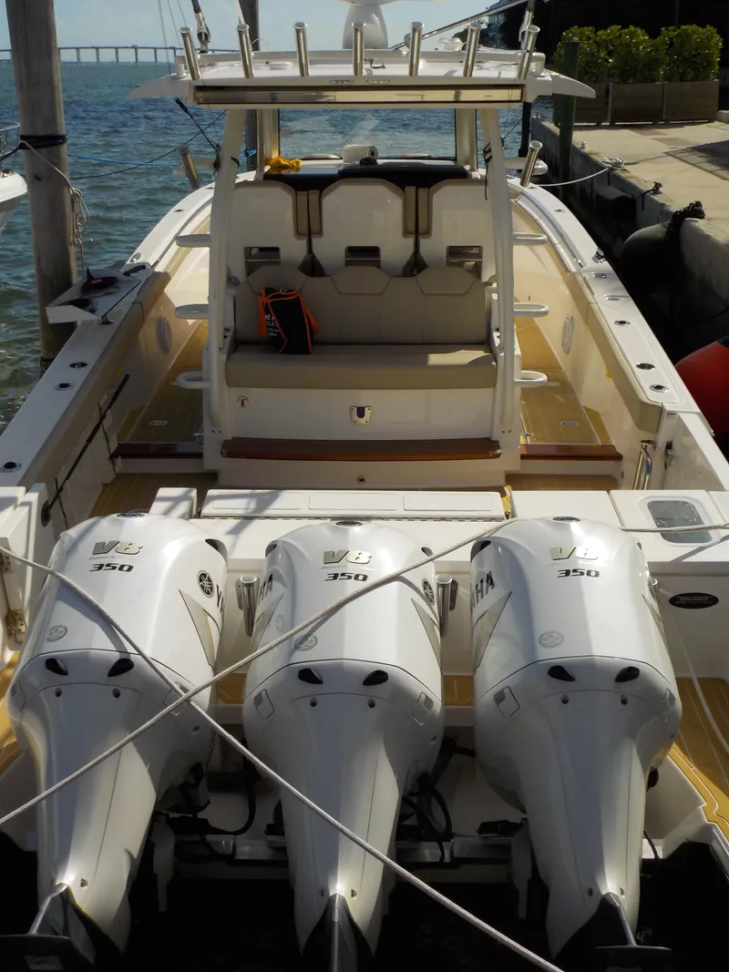 Slide: The Image of 2019 Pursuit S 368 boat with triple Yamaha 350 engines docked by the water. - 4