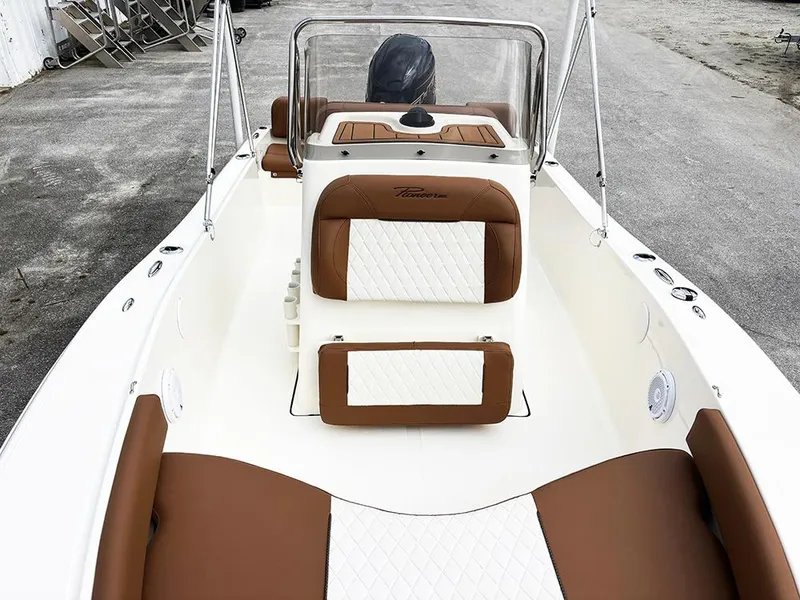 Slide: The Image of 2025 Pioneer 180 Islander boat interior with brown and white seating, sleek design. - 10
