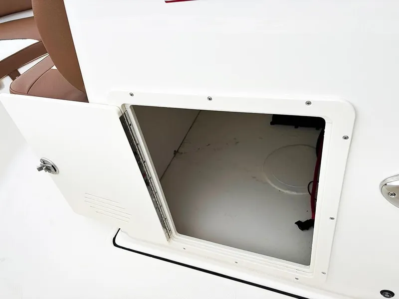 Slide: The Image of Open storage compartment on 2025 Pioneer 180 Islander boat, featuring white interior and secure latch. - 18