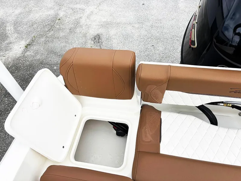Slide: The Image of 2025 Pioneer 180 Islander boat seating with storage compartment, featuring brown and white upholstery. - 23