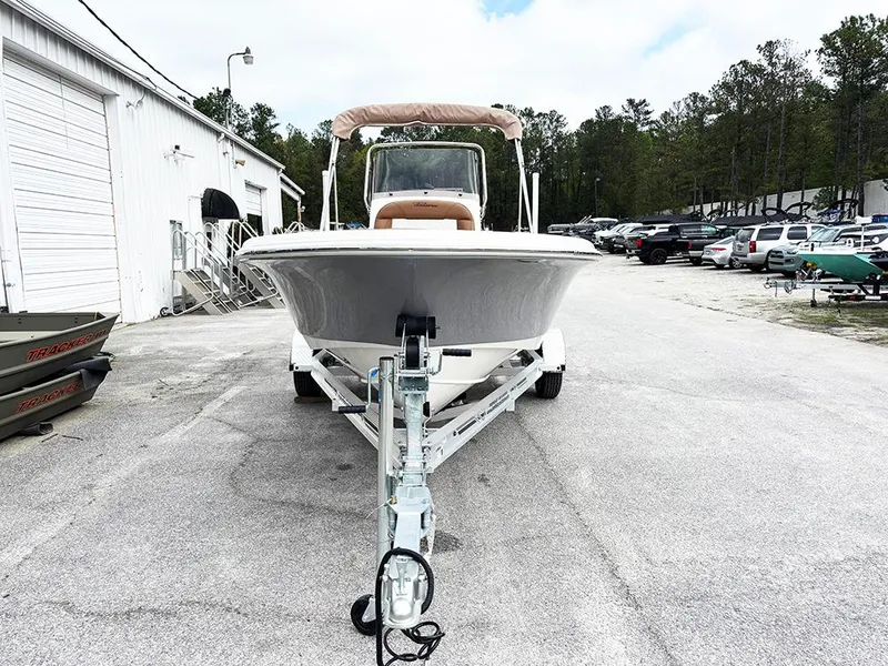 Slide: The Image of 2025 Pioneer 180 Islander boat on trailer, parked outdoors near a building and trees. - 3