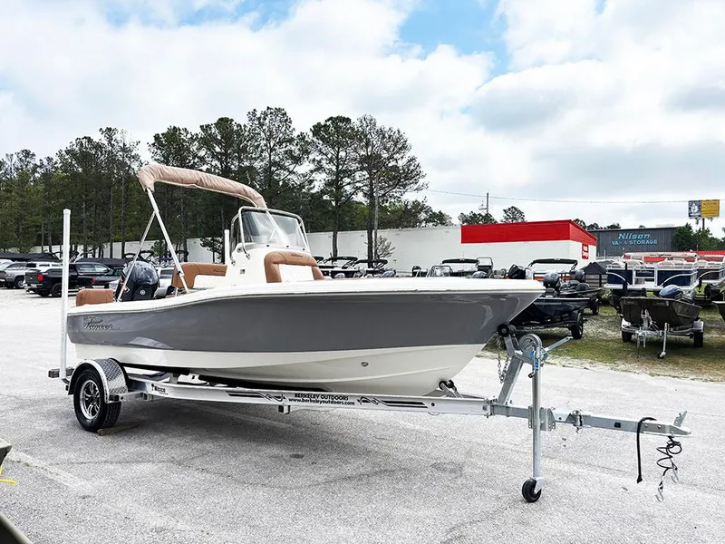 Slide: The Image of 2025 Pioneer 180 Islander boat on trailer, parked outdoors under cloudy sky. - 4