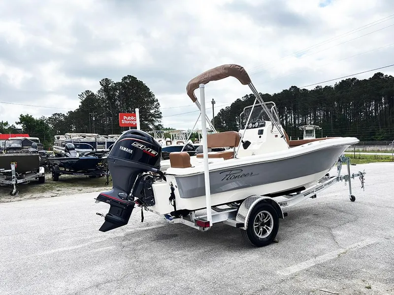 Slide: The Image of 2025 Pioneer 180 Islander boat with Yamaha outboard motor on a trailer, parked outdoors. - 6