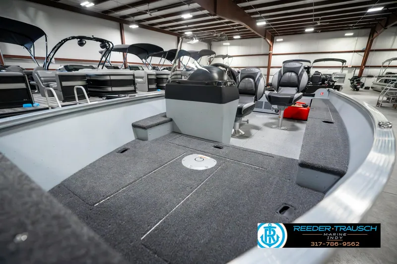 Slide: The Image of 2025 Lund 1600 Fury boat interior in showroom, featuring spacious seating and modern design. - 19