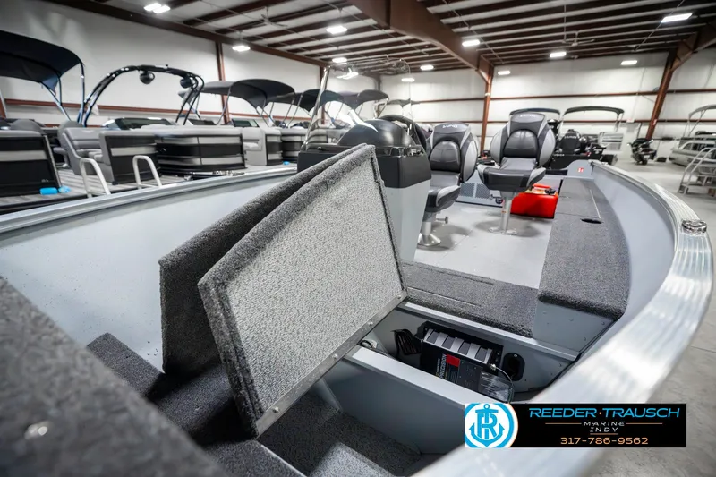 Slide: The Image of 2025 Lund 1600 Fury boat interior in showroom, featuring seating and storage compartments. - 20