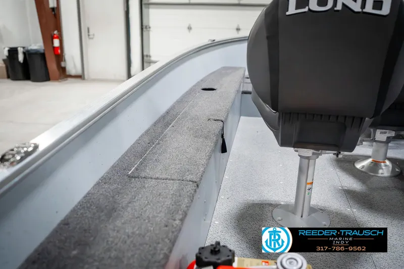 Slide: The Image of 2025 Lund 1600 Fury boat interior with seating and storage, displayed in a showroom. - 24