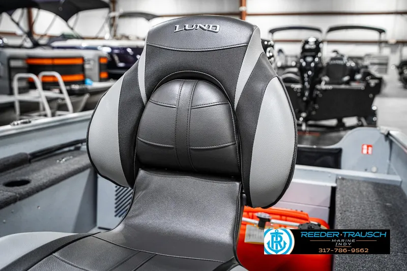 Slide: The Image of 2025 Lund 1600 Fury boat seat in showroom, featuring sleek black and gray design. - 33