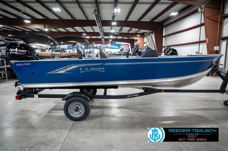 Slide: The Image of 2025 Lund 1600 Fury boat in showroom, blue exterior, on trailer. - 5