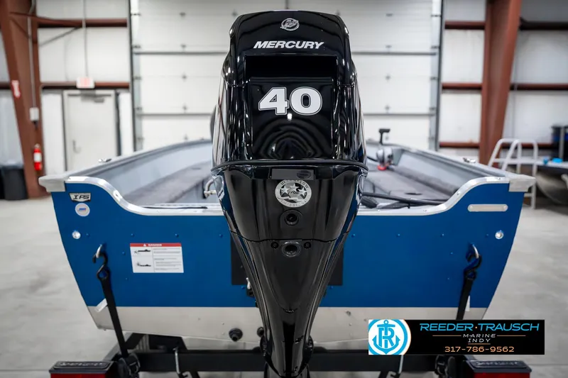 Slide: The Image of 2025 Lund 1600 Fury boat with Mercury 40 engine in a garage setting. - 7