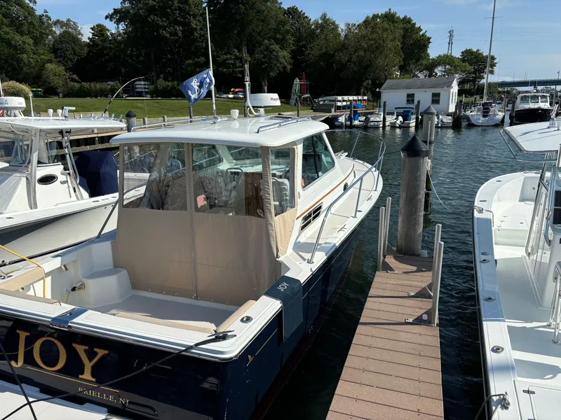Slide: The Image of 2007 Back Cove 29 boat docked at marina, surrounded by other vessels. - 0