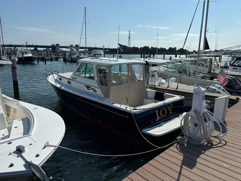 Slide: The Image of 2007 Back Cove 29 boat named "Joy" docked at a marina. - 1