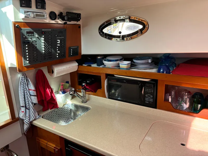 Slide: The Image of 2007 Back Cove 29 yacht kitchen with sink, microwave, and storage shelves. - 10