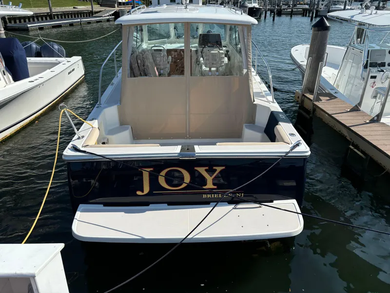 Slide: The Image of 2007 Back Cove 29 boat named "Joy" docked at a marina. - 2