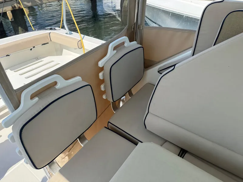 Slide: The Image of 2007 Back Cove 29 boat interior with beige seating and foldable chairs. - 4
