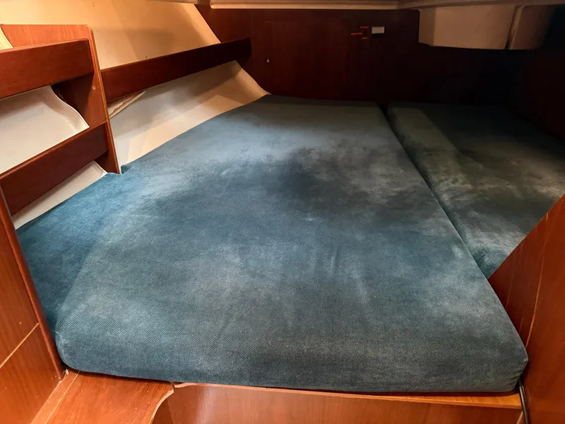 Slide: The Image of Cabin interior of 1998 Beneteau Oceanis 352 sailboat with blue cushioned bed. - 10