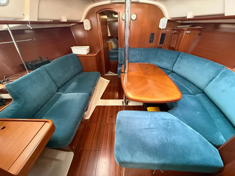 Slide: The Image of Interior of 1998 Beneteau Oceanis 352 sailboat with blue seating and wooden table. - 14