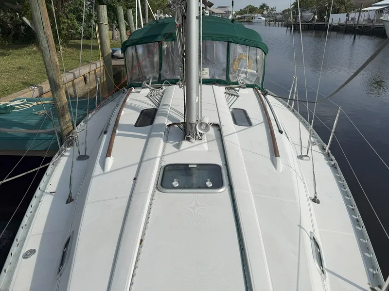 Slide: The Image of 1998 Beneteau Oceanis 352 sailboat docked, featuring a clean deck and green canopy. - 4