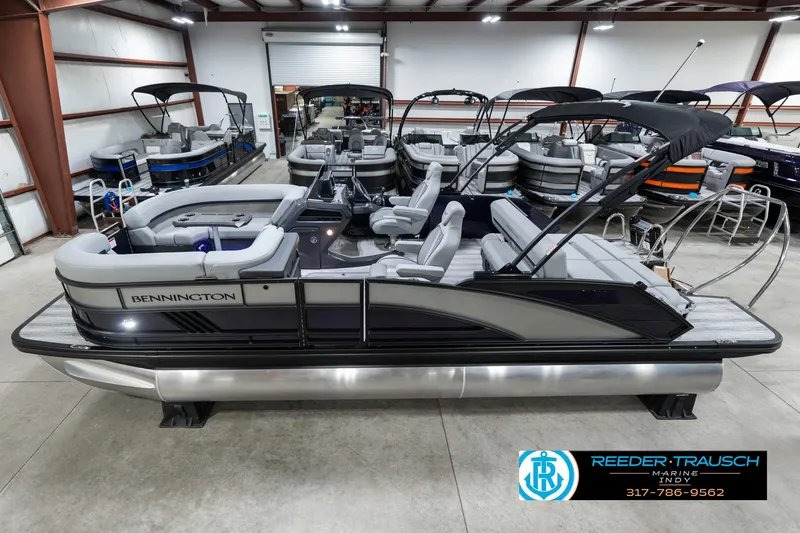 Slide: The Image of 2025 Bennington 22 MSB pontoon boat in showroom, featuring sleek design and spacious seating. - 1
