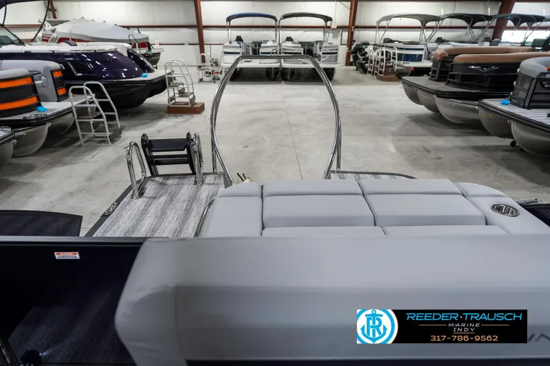 Slide: The Image of 2025 Bennington 22 MSB pontoon boat in showroom with multiple boats displayed. - 17