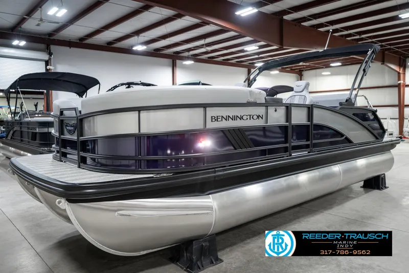 Slide: The Image of 2025 Bennington 22 MSB pontoon boat displayed in a showroom. - 2