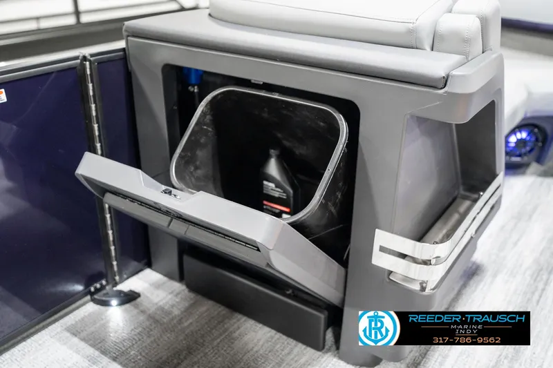 Slide: The Image of 2025 Bennington 22 MSB boat storage compartment with open hatch and visible bottle inside. - 26