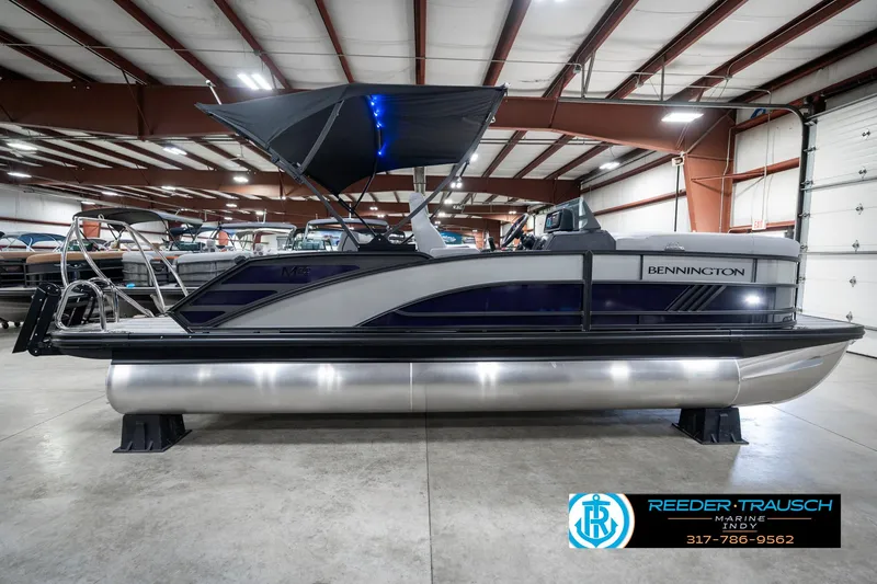 Slide: The Image of 2025 Bennington 22 MSB pontoon boat in showroom with canopy and sleek design. - 6