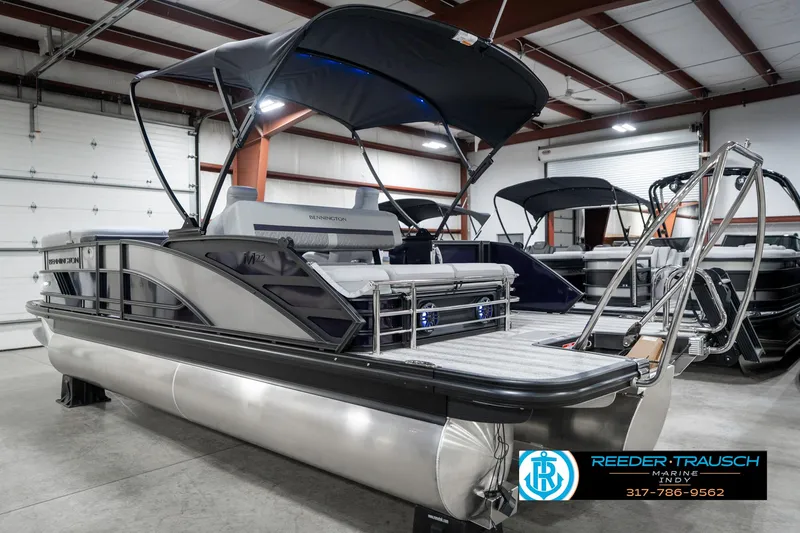 Slide: The Image of 2025 Bennington 22 MSB pontoon boat in showroom with canopy and sleek design. - 9