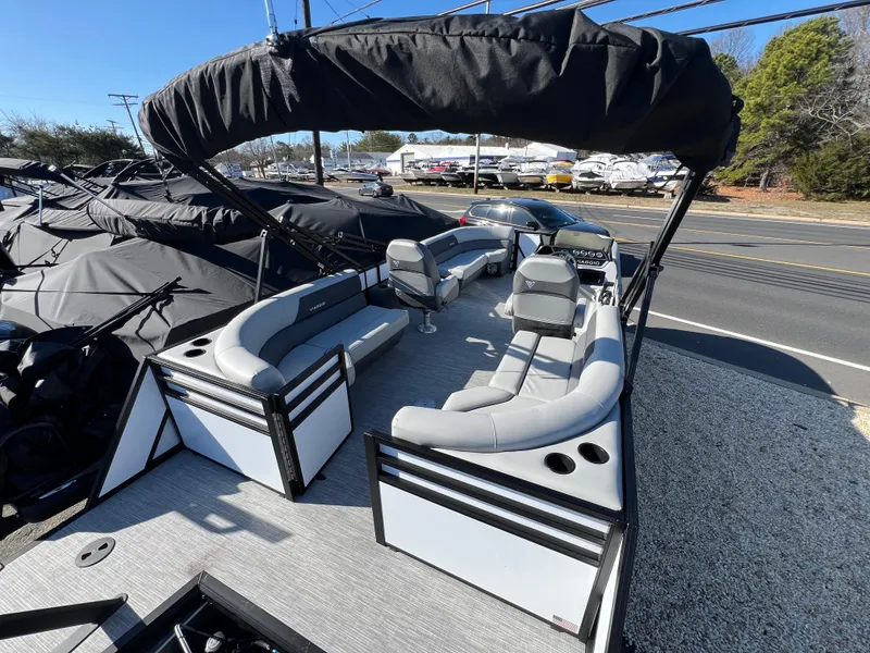 Slide: The Image of 2025 Viaggio Lago V20U pontoon boat with spacious seating and canopy, parked near a road. - 10