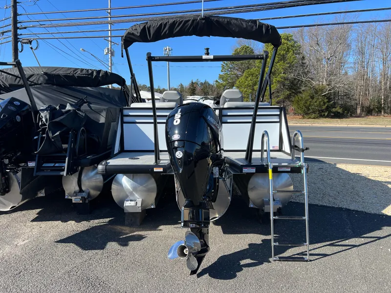 Slide: The Image of 2025 Viaggio Lago V20U pontoon boat with outboard motor and ladder, parked outdoors. - 9