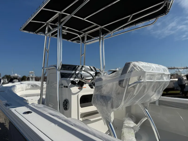 Slide: The Image of 2025 Parker 21SE boat with T-top and wrapped seating, under clear blue sky. - 2