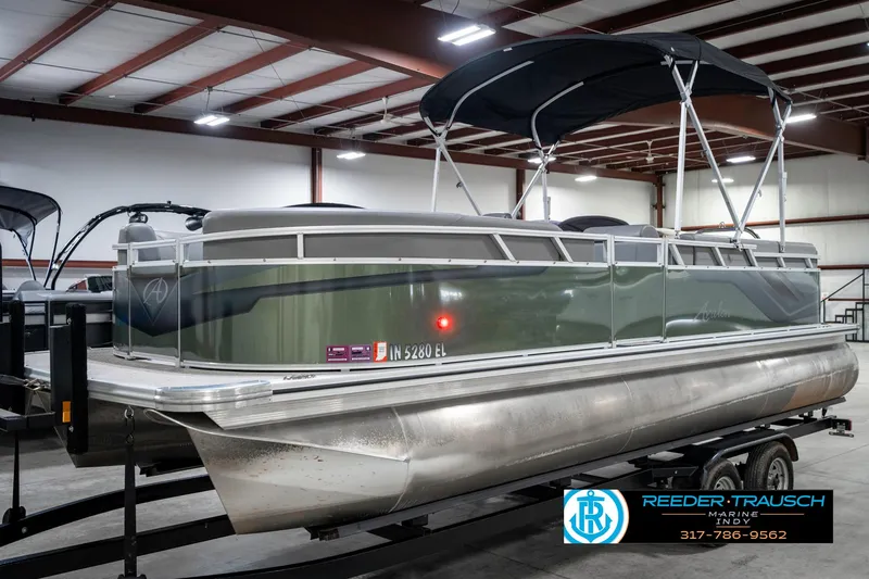 Slide: The Image of 2023 Avalon 2380 VLS pontoon boat in a warehouse, featuring a sleek design and canopy. - 3