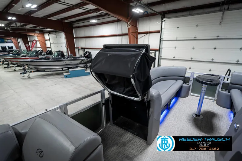 Slide: The Image of 2023 Avalon 2380 VLS pontoon boat interior in showroom with seating and blue LED lighting. - 30