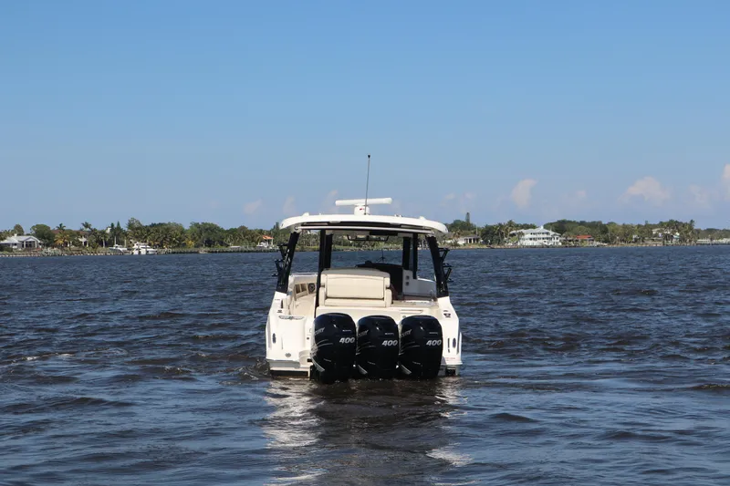 Slide: The Image of 2023 Boston Whaler 350 Realm boat on open water with triple engines. - 10