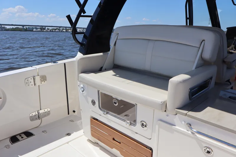 Slide: The Image of 2023 Boston Whaler 350 Realm boat interior with white seating and storage compartments. - 12