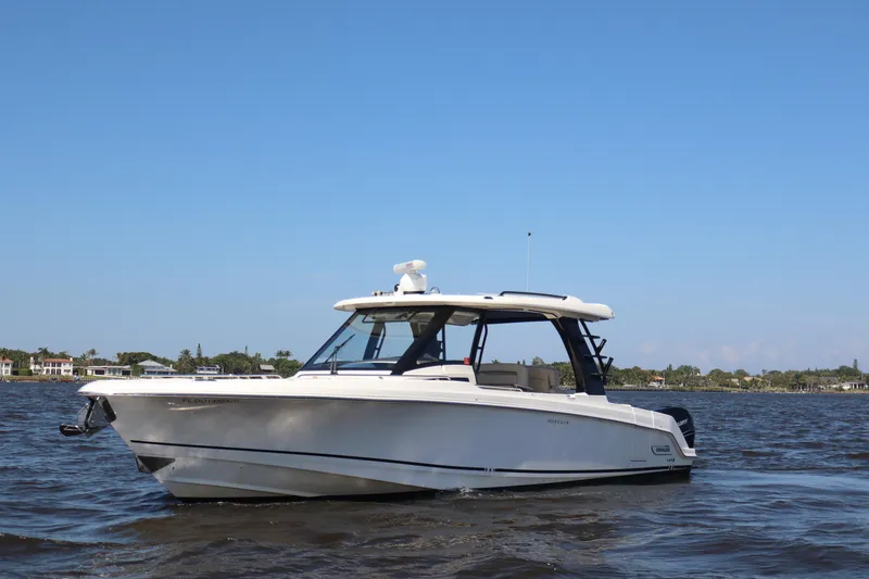 Slide: The Image of 2023 Boston Whaler 350 Realm boat on calm water under clear blue sky. - 15