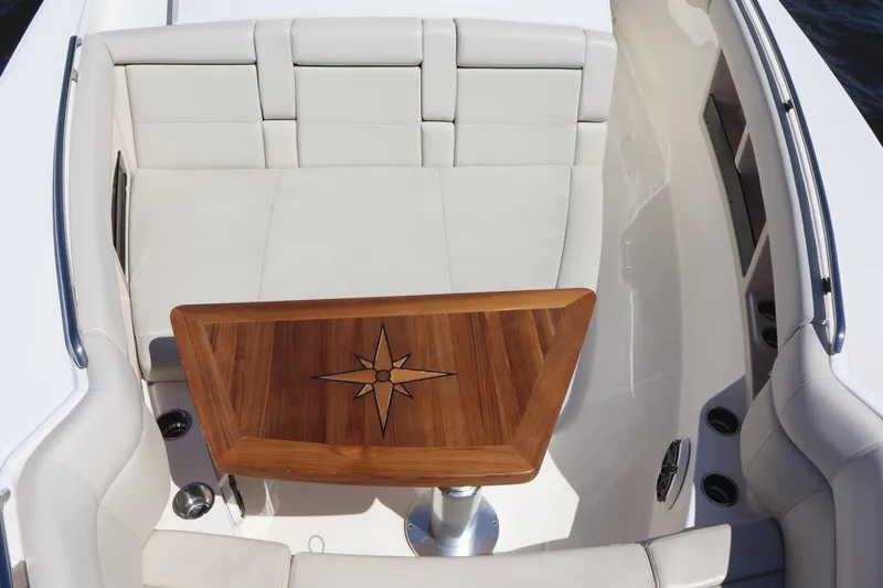 Slide: The Image of 2023 Boston Whaler 350 Realm interior with elegant seating and wooden table. - 16