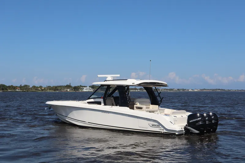 Slide: The Image of 2023 Boston Whaler 350 Realm boat on open water under clear blue sky. - 2