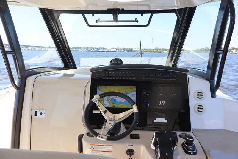 Slide: The Image of 2023 Boston Whaler 350 Realm helm with navigation display on open water. - 23