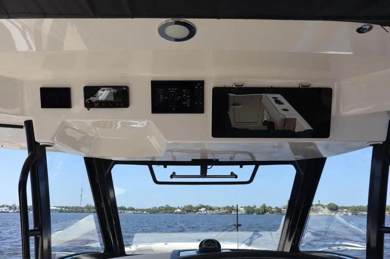 Slide: The Image of 2023 Boston Whaler 350 Realm helm with advanced navigation systems and panoramic water view. - 24