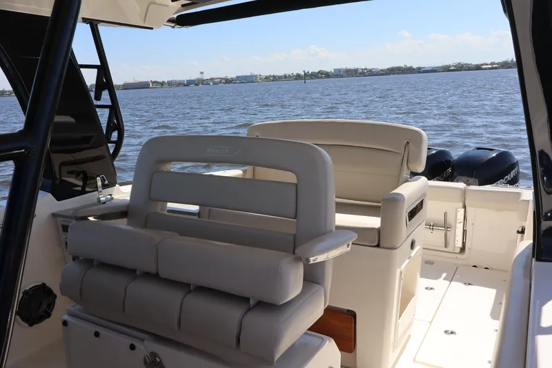 Slide: The Image of 2023 Boston Whaler 350 Realm boat interior with seating, overlooking calm waters. - 25