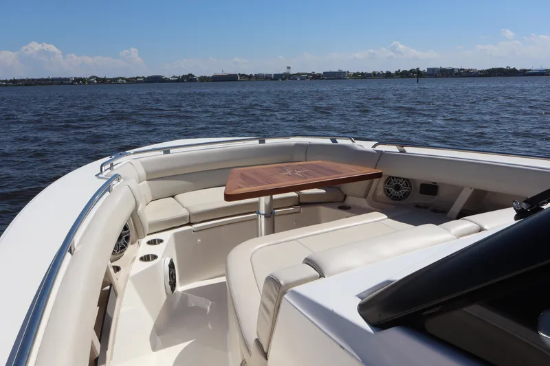Slide: The Image of 2023 Boston Whaler 350 Realm boat interior with seating and table on open water. - 27