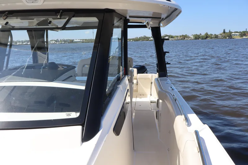 Slide: The Image of 2023 Boston Whaler 350 Realm boat on calm water, showcasing sleek design and spacious deck. - 28