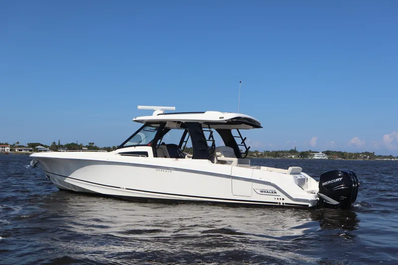Slide: The Image of 2023 Boston Whaler 350 Realm boat on water, side view, clear sky background. - 3