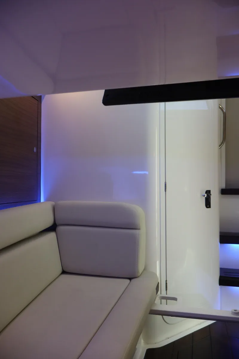 Slide: The Image of Interior of 2023 Boston Whaler 350 Realm, featuring modern seating and ambient lighting. - 31