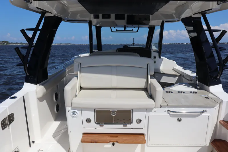 Slide: The Image of 2023 Boston Whaler 350 Realm boat interior with seating and ocean view. - 43