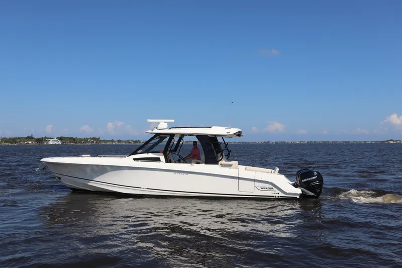 Slide: The Image of 2023 Boston Whaler 350 Realm boat cruising on open water under clear blue skies. - 5