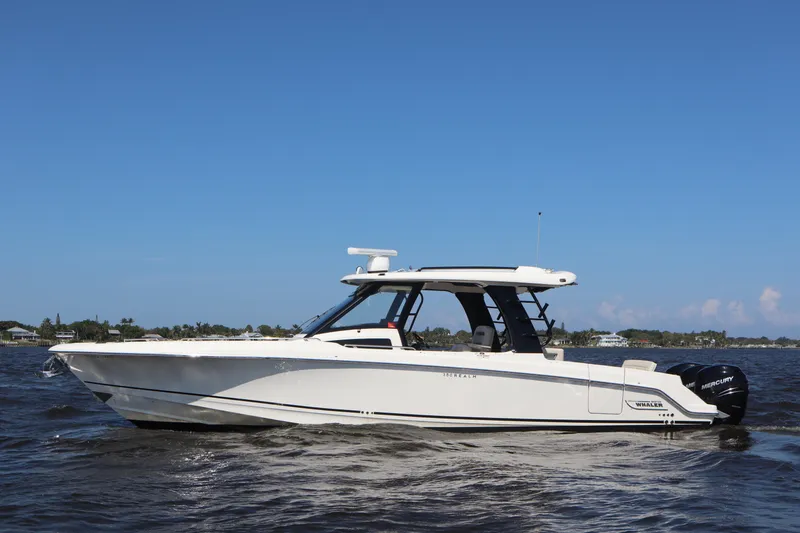 Slide: The Image of 2023 Boston Whaler 350 Realm boat cruising on open water under clear blue sky. - 6