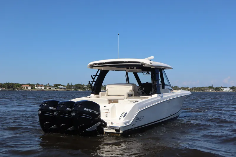 Slide: The Image of 2023 Boston Whaler 350 Realm boat on water with triple Mercury engines. - 7