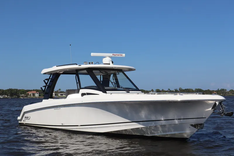 Slide: The Image of 2023 Boston Whaler 350 Realm boat on water under clear blue sky. - 8