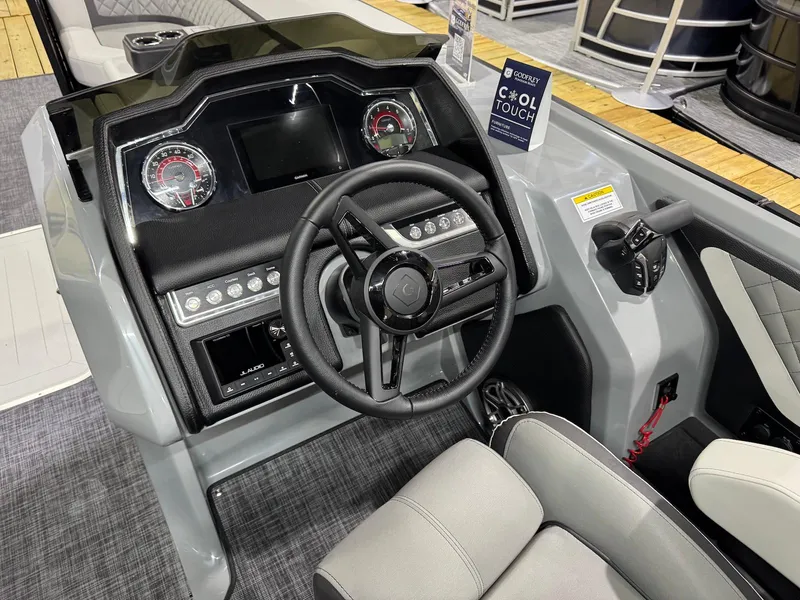 Slide: The Image of Interior view of 2025 Godfrey AquaPatio 255 ULC boat dashboard and steering wheel. - 8